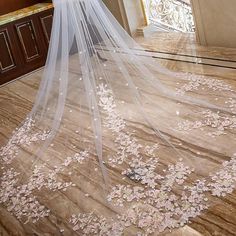 a wedding veil with flowers on it is in the middle of a flooring area