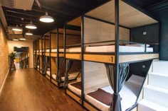 bunk beds are lined up in the middle of a room with stairs leading to them