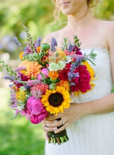 a woman holding a bouquet of flowers in her hands