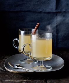 two glasses filled with liquid and cinnamon sticks