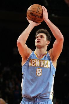 a basketball player is getting ready to dunk the ball in front of his head