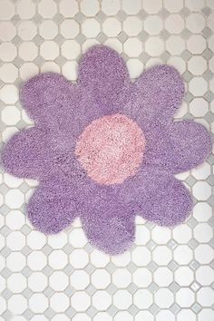 a purple flower rug sitting on top of a white tiled floor