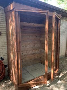 an outdoor wooden sauna in front of a brick building