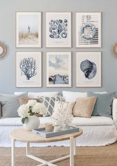 a living room filled with lots of pictures on the wall above a white couch and coffee table