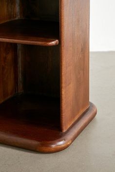 a wooden shelf sitting on top of a cement floor