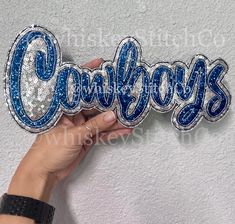 someone is holding onto the word coolfoys in blue and silver sequins