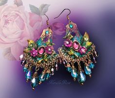 "This pair of boho chandeliers is made with ornate layered filigrees, ombre shades of Amethyst to Peacock Teal crystal teardrops with a central Amethyst glass stone.  Floral hand-painted and antiqued stampings embellish the pendant for a unique, exotic appeal.   Swarovski rhinestones enhance the subtle sparkle!  Available in Posts, Clip-Ons or French Wires. -3 1/4\" Long x 1 3/4\" wide. -0.4 oz. ea Metal Finishes Available: -Brass (as pictured) -Silver *Comes Ready To Gift in Decorative Packaging *Each Pair is Made Just for You!  Kerala Rose Pinterest page: https://www.pinterest.com/keralarose3/pins/ To re-enter my shop, Kerala Rose: https://www.etsy.com/shop/kerala" Bohemian Peacock Design Earrings For Party, Ornate Handmade Chandelier Earrings For Festival, Bohemian Chandelier Earrings With Filigree For Parties, Bohemian Chandelier Earrings With Intricate Design, Bohemian Purple Earrings For Wedding, Bohemian Dangle Chandelier Earrings With Intricate Design, Bohemian Chandelier Dangle Earrings With Intricate Design, Handmade Ornate Chandelier Earrings For Parties, Ornate Handmade Chandelier Earrings For Party