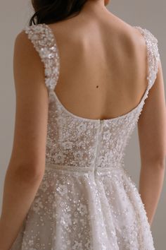 the back of a woman's wedding dress with sequins