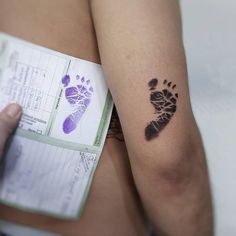 a person's hand and foot prints on the back of their left arm, next to a passport