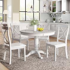 a white kitchen table with four chairs around it