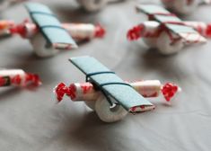 several small toy airplanes sitting on top of a table covered in red and white paper