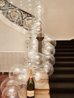 a bottle of champagne sitting on top of a wooden table next to some clear bubbles