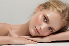 a naked woman laying on top of a white table