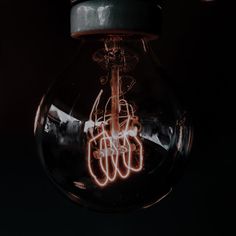 a light bulb that is lit up with neon writing on the inside and in the middle