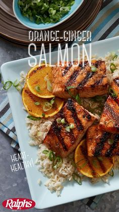 the cover of orange - ginger salmon is shown on a plate with rice and sliced oranges