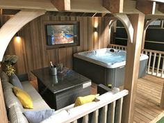 a hot tub sitting on top of a wooden floor next to a tv mounted above it