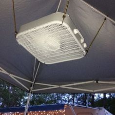 a white fan sitting on top of a tent