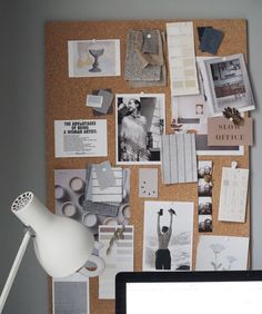 a cork board covered in pictures and magnets next to a laptop computer on a desk