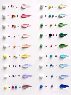 an array of different colored paint drops on a white surface, with one drop in the middle