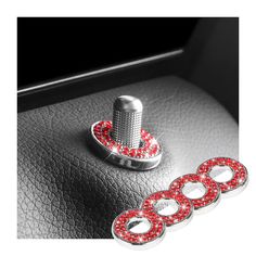 a car dashboard with red and white beads on the center console, and two silver knobs