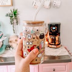 a person holding a glass jar with a straw in it on top of a counter