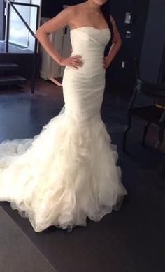 a woman in a wedding dress posing for the camera