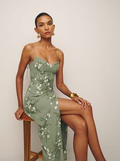 a woman in a green dress sitting on a chair