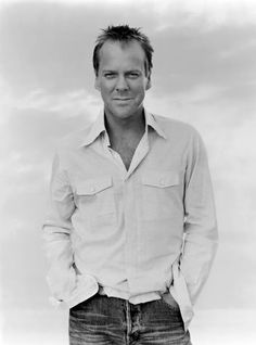 a black and white photo of a man in a button up shirt posing for the camera