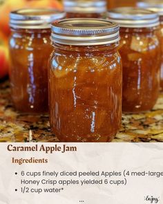 four jars filled with apple jam sitting on top of a counter