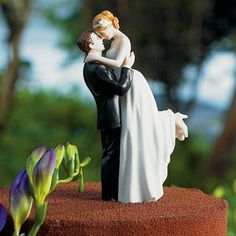 a bride and groom figurine standing on top of a hill