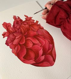 a drawing of a human heart with red flowers on it and a pair of scissors in the foreground