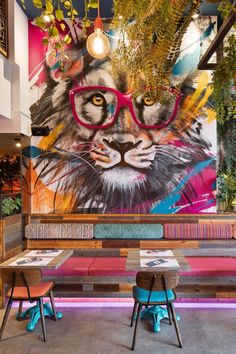 a colorful mural behind two tables with chairs