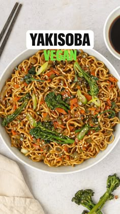 a bowl of noodles with broccoli, carrots and sesame seeds in it