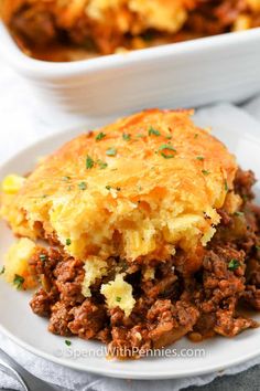 a close up of a plate of food with lasagna on it and another dish in the background