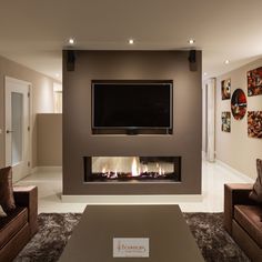 a living room with couches and a flat screen tv mounted above the fire place