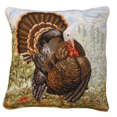 a cross stitch pillow with a turkey on it's back and an image of a tree in the background