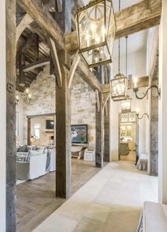 the inside of a house with wood beams and chandeliers hanging from the ceiling