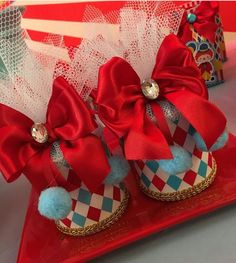 two red and white shoes with bows on them are sitting on a plate next to each other