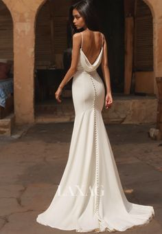 a woman in a white wedding dress with an open back and pearls on the side