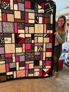 a woman standing next to a large quilt