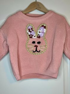 a pink sweater with bunny ears on it