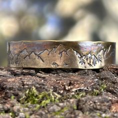 Whether you're looking for a birthday gift, or celebrating your anniversary, a thoughtful gift is a must! This solid bronze cuff bracelet is the perfect answer.  Side note: bronze is the traditional gift for both 8th and 19th anniversary.  This handmade bronze bracelet features stamped images of mountains and trees, which celebrate the natural beauty and majesty of the forest. It is ideal for outdoor enthusiasts such as hikers and hunters. Each piece is unique due to the hand-forged process and Spiritual Bronze Jewelry For Anniversary, Engraved Bronze Jewelry Gift, Engraved Bronze Rings Ideal For Gifts, Bronze Engraved Rings Ideal For Gifts, Bronze Engraved Rings For Gift, Engraved Bronze Rings Gift, Bronze Engraved Jewelry For Anniversary, Unique Engraved Anniversary Bracelets, Adjustable Etched Jewelry As A Gift