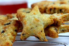 some cookies are cooling on a rack with one star shaped cookie next to the other