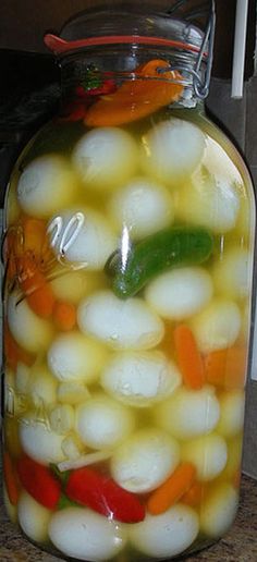 a jar filled with vegetables sitting on top of a counter