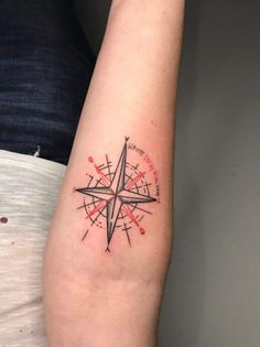 a small compass tattoo on the arm