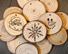 some wood slices with designs on them are arranged in a circular pattern and have snowflakes drawn on them