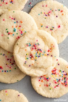 white sugar cookies with colorful sprinkles on a gray table top, ready to be eaten