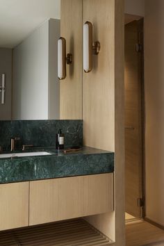 a bathroom with two sinks and green marble counter tops