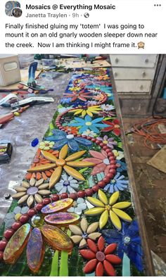 the table is covered with many different colored glass flowers and bead spools