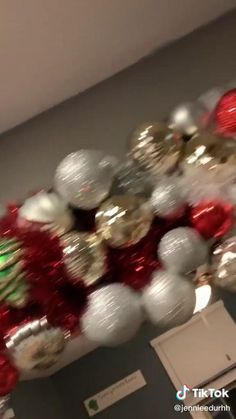 christmas decorations are hanging from the ceiling in this hallway decorated with red, white and gold ornaments